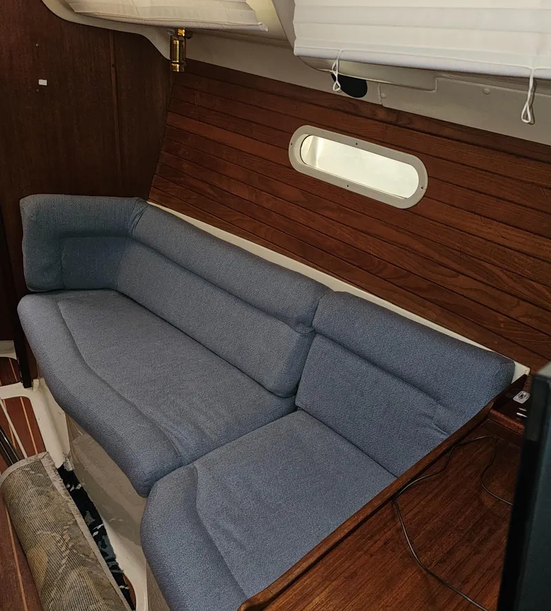 Slide: The Image of Interior of a 1995 Hunter 336 sailboat with blue cushioned seating. - 10