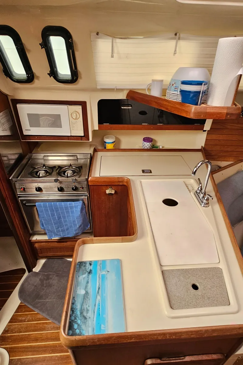 Slide: The Image of 1995 Hunter 336 yacht interior kitchen with stove, sink, and microwave. - 12