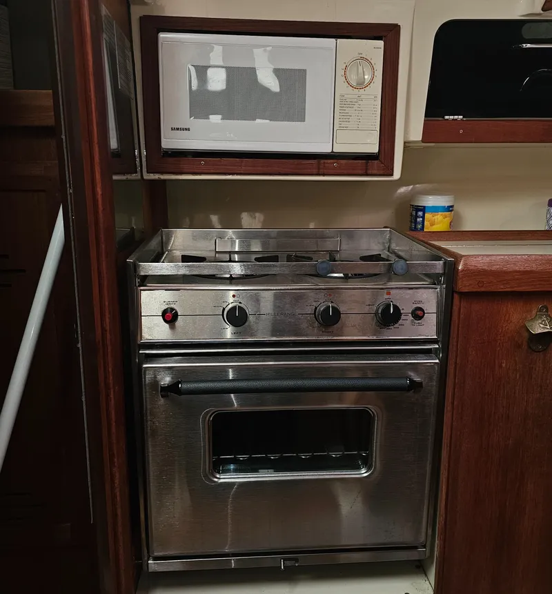 Slide: The Image of Compact kitchen with stainless steel stove and microwave in a 1995 Hunter 336. - 13