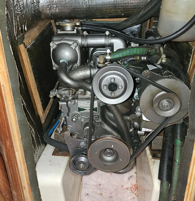 Slide: The Image of Engine compartment of a 1995 Hunter 336 sailboat, showcasing mechanical components and belts. - 24