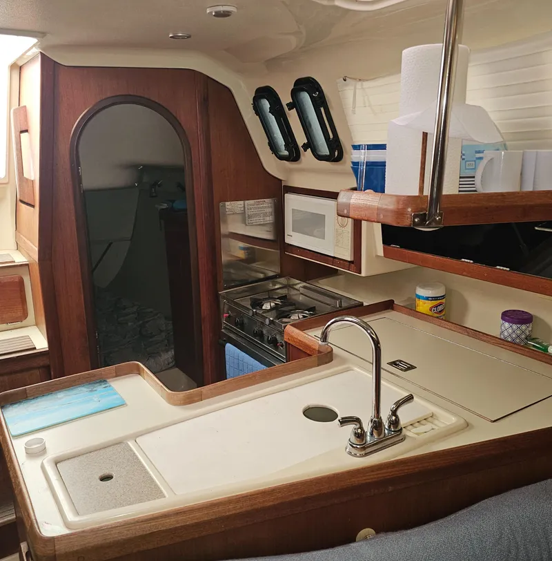 Slide: The Image of Interior of a 1995 Hunter 336 sailboat, featuring a compact kitchen and cozy cabin space. - 5