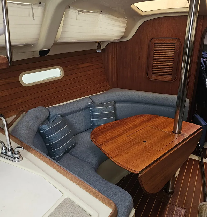 Slide: The Image of Cozy interior of 1995 Hunter 336 sailboat with wooden table and cushioned seating. - 6