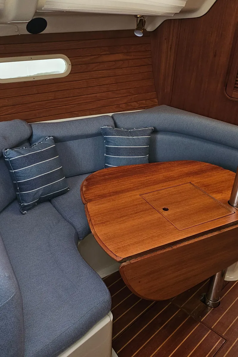 Slide: The Image of Interior of 1995 Hunter 336 sailboat with wooden table and blue seating. - 7