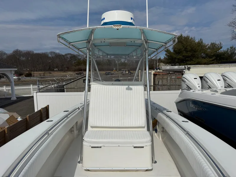 Slide: The Image of 2010 Contender 25 Open boat with T-top and seating, docked outdoors. - 4