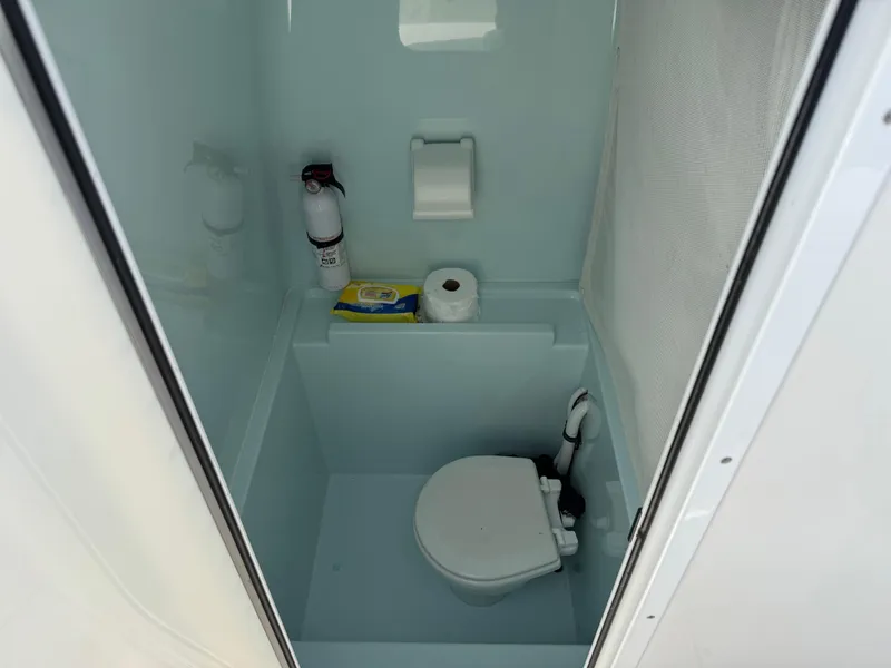 Slide: The Image of Compact marine toilet in a 2010 Contender 25 Open boat, featuring essential amenities. - 9
