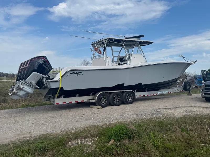 Slide: The Image of 2021 Invincible 39 Open Fisherman boat on trailer, parked outdoors under a cloudy sky. - 0