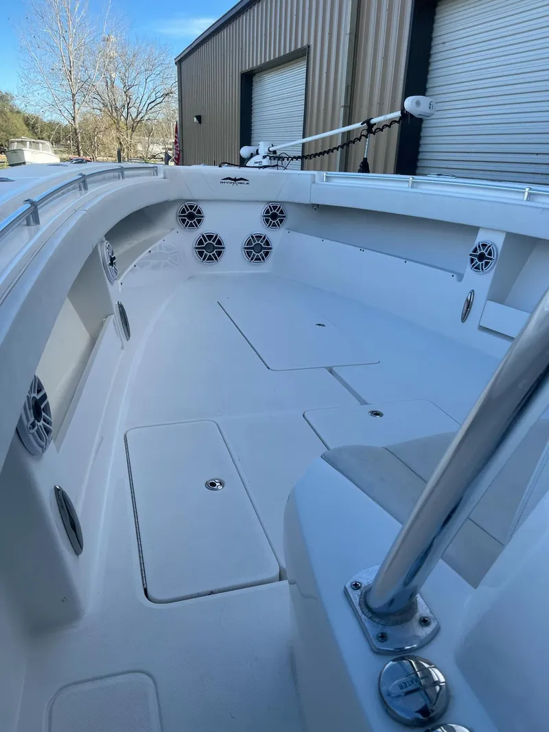 Slide: The Image of 2021 Invincible 39 Open Fisherman boat, spacious deck, modern design, docked near a warehouse. - 5