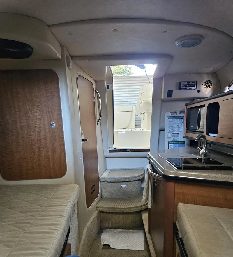 Slide: The Image of Interior of 2006 Sea Ray 270 Amberjack boat, featuring kitchenette and seating area. - 12