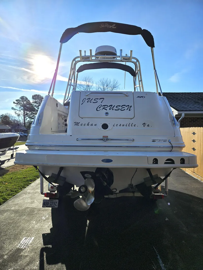 Slide: The Image of 2006 Sea Ray 270 Amberjack boat, rear view, with "Just Crusen" text, parked outdoors. - 5