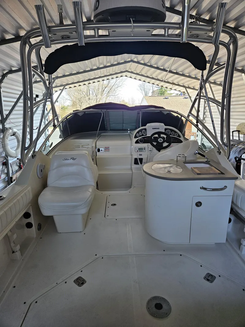 Slide: The Image of 2006 Sea Ray 270 Amberjack boat interior with helm, seating, and kitchenette under a canopy. - 7