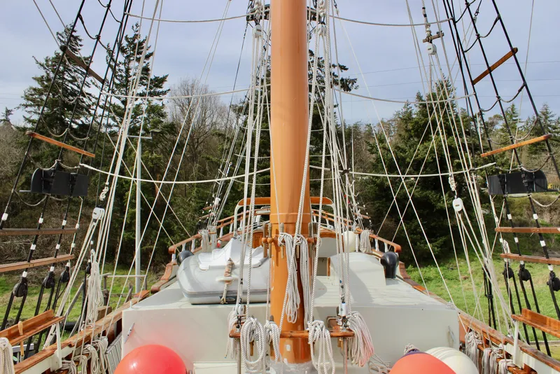 Slide: The Image of Custom Lahaina Welding Co. Square Topsail Ketch, 1988, with rigging and deck view, surrounded by trees. - 17