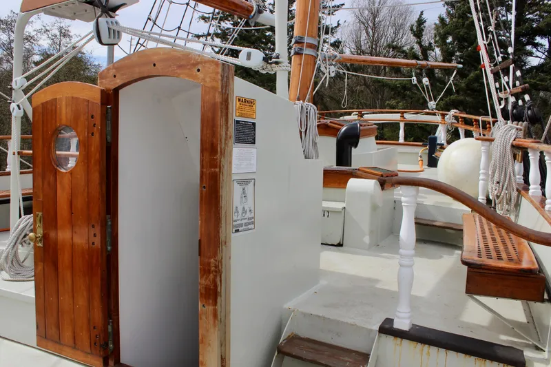 Slide: The Image of 1988 Custom Lahaina Welding Co. Square Topsail Ketch deck with wooden details and open cabin door. - 27