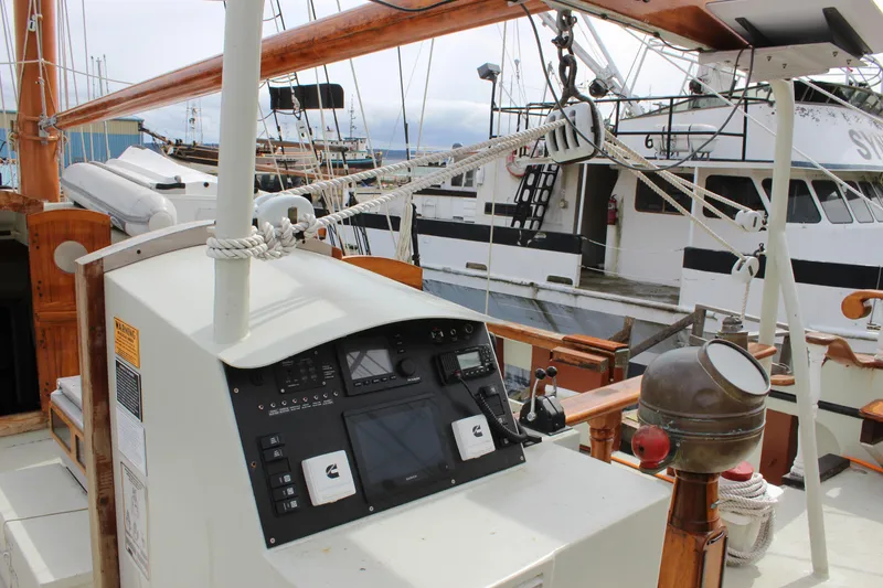 Slide: The Image of Cockpit view of 1988 Lahaina Welding Co. Square Topsail Ketch, featuring navigation equipment and nearby boats. - 36