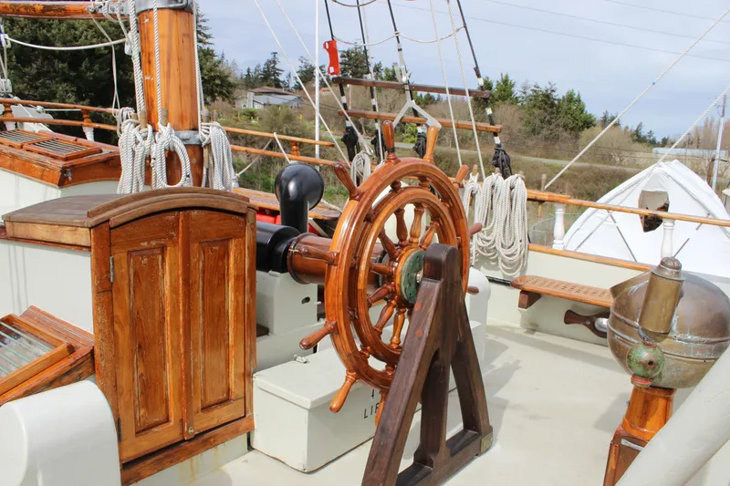Slide: The Image of Wooden helm of 1988 Custom Lahaina Welding Co. Square Topsail Ketch, with ropes and nautical equipment. - 39
