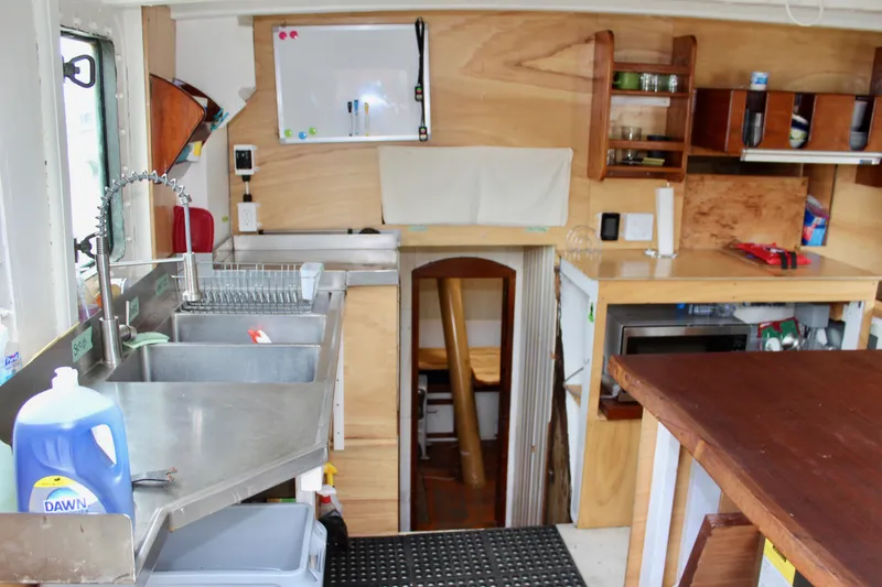 Slide: The Image of Interior of 1988 Lahaina Welding Co. Square Topsail Ketch with kitchen and wooden cabinetry. - 40