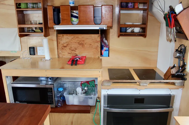 Slide: The Image of Compact kitchen in 1988 Lahaina Welding Co. Square Topsail Ketch with microwave, stove, and storage shelves. - 45