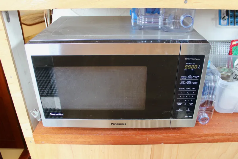 Slide: The Image of Microwave oven on wooden shelf, Panasonic brand, digital display, kitchen setting. - 48