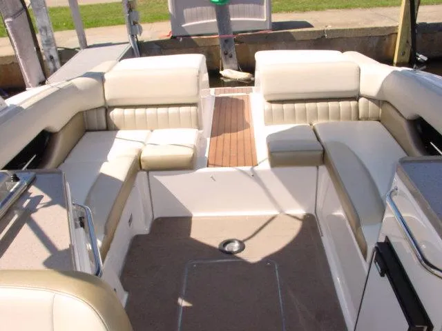 Slide: The Image of 2011 Regal 2750 Cuddy boat interior with beige seating and wood flooring. - 10