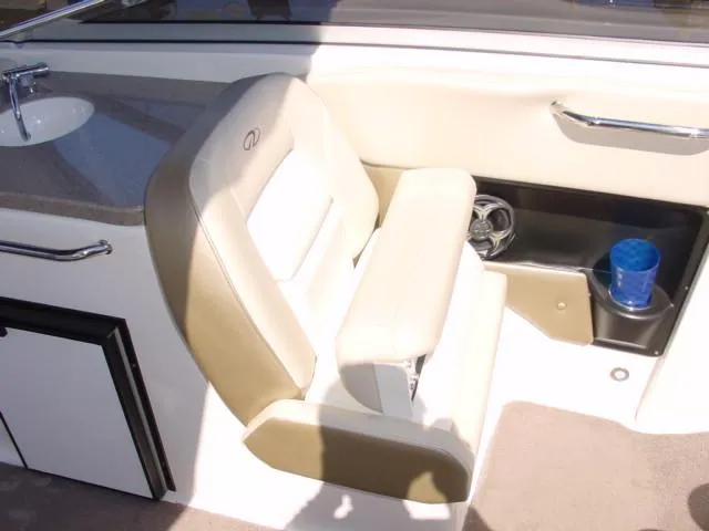 Slide: The Image of 2011 Regal 2750 Cuddy interior with beige seating and built-in cup holder. - 11