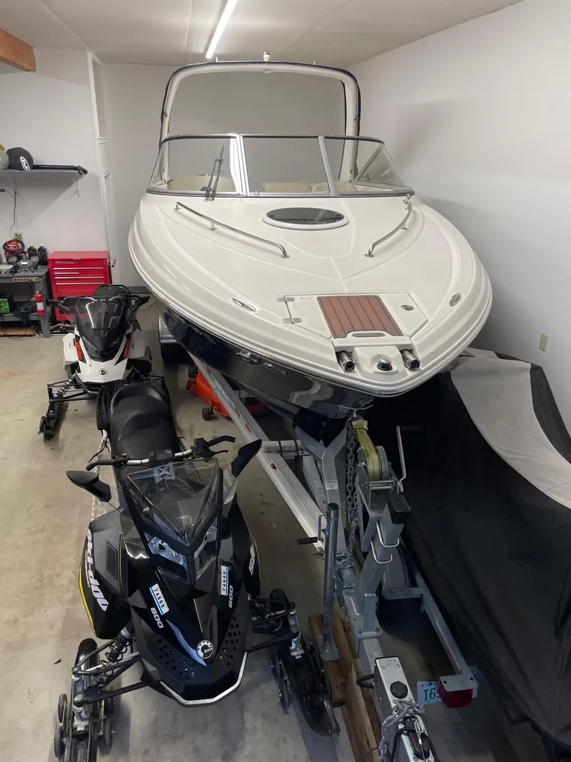 Slide: The Image of 2011 Regal 2750 Cuddy boat in garage with snowmobiles. - 17