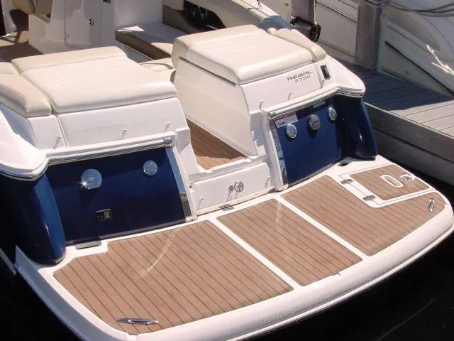 Slide: The Image of 2011 Regal 2750 Cuddy boat with spacious teak swim platform and cushioned seating. - 2