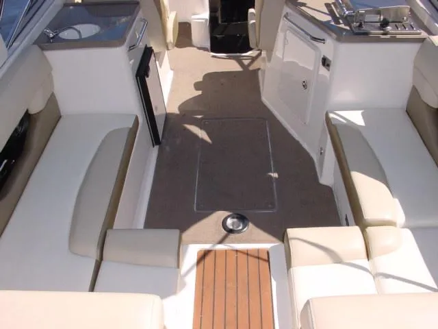 Slide: The Image of 2011 Regal 2750 Cuddy boat interior with beige seating and modern amenities. - 3
