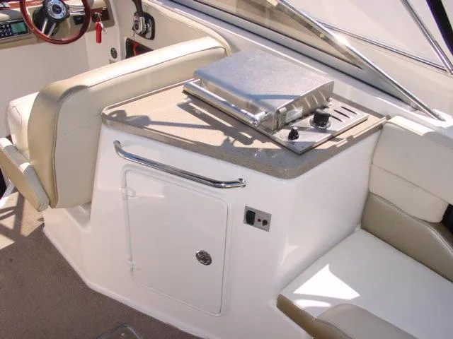 Slide: The Image of 2011 Regal 2750 Cuddy boat interior with seating and built-in grill. - 4
