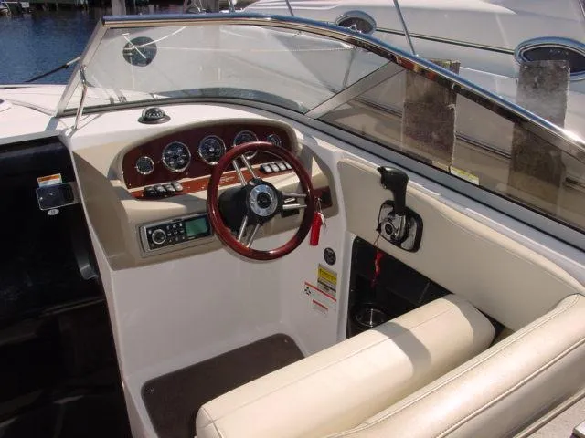 Slide: The Image of 2011 Regal 2750 Cuddy boat cockpit with steering wheel and control panel. - 5