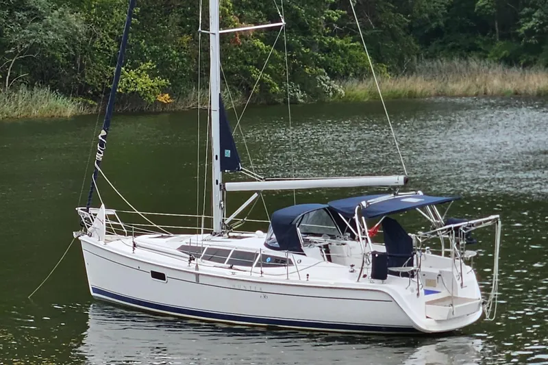 Slide: The Image of 2011 Hunter e36 sailboat on calm water, surrounded by lush greenery. - 0