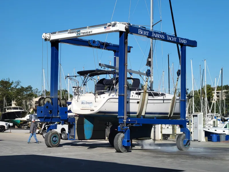 Slide: The Image of Boat being lifted at Bert Jabin's Yacht Yard, featuring a 2011 Hunter e36 model. - 13
