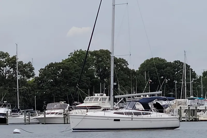 Slide: The Image of Sailboat Hunter e36 2011 docked in marina with other boats and trees in background. - 3