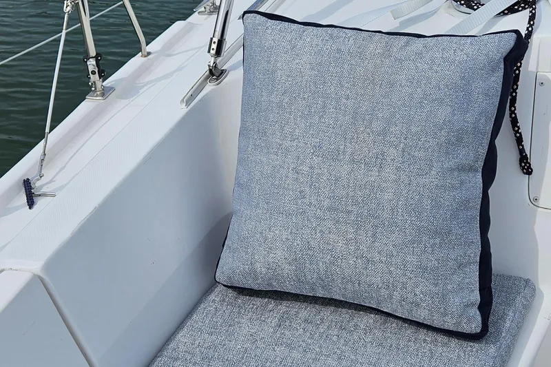 Slide: The Image of Cushioned seating on a 2011 Hunter e36 sailboat deck, featuring a blue pillow. - 35