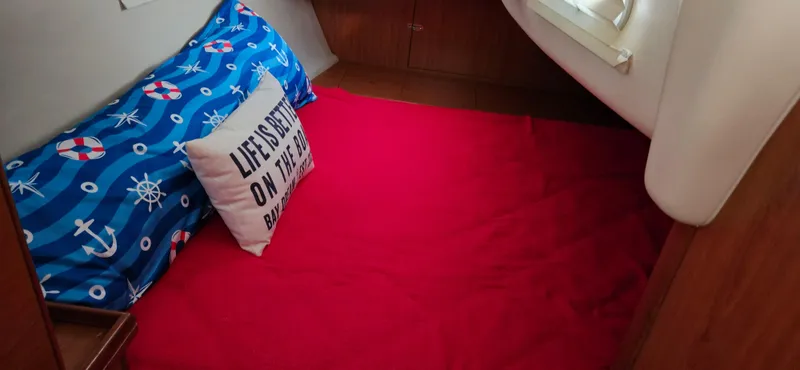 Slide: The Image of Cozy cabin interior of 2011 Hunter e36 with nautical-themed bedding and decorative pillow. - 39