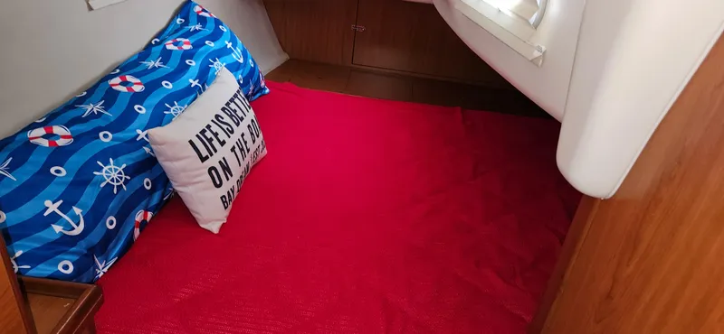 Slide: The Image of Cozy cabin interior of 2011 Hunter e36 with nautical-themed bedding and vibrant red carpet. - 40