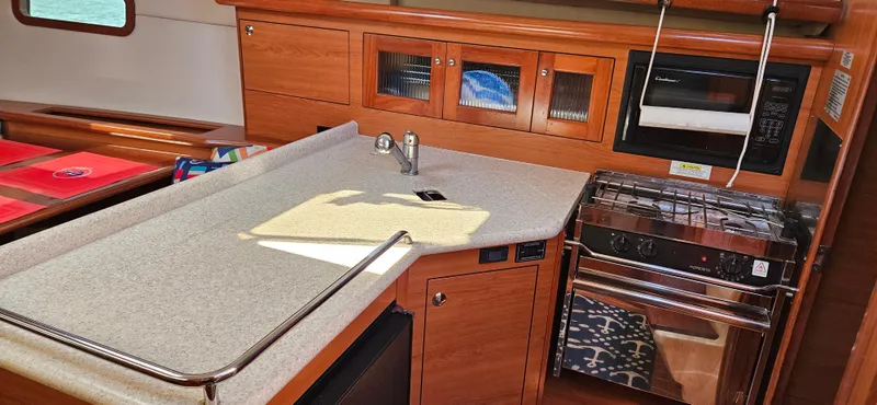 Slide: The Image of Interior of 2011 Hunter e36 yacht kitchen with stove, sink, and wooden cabinetry. - 47