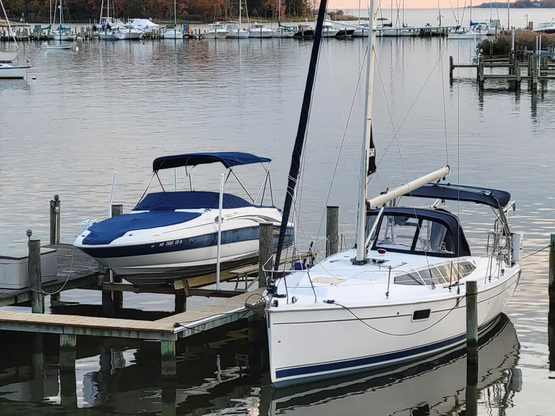 Slide: The Image of Sailboat and motorboat docked at a serene marina, featuring a 2011 Hunter e36. - 8