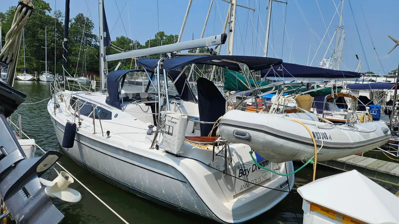 Slide: The Image of 2011 Hunter e36 sailboat docked with inflatable dinghy, surrounded by other boats. - 9