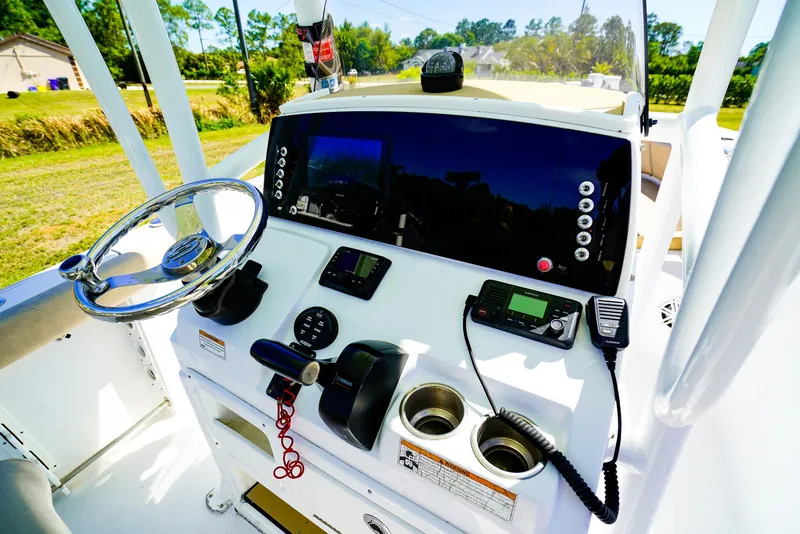 Slide: The Image of 2019 Sportsman 232 Open Platinum boat dashboard with steering wheel and navigation controls. - 13