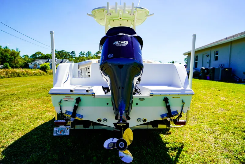 Slide: The Image of 2019 Sportsman 232 Open Platinum boat with powerful outboard motor, parked on grass. - 18