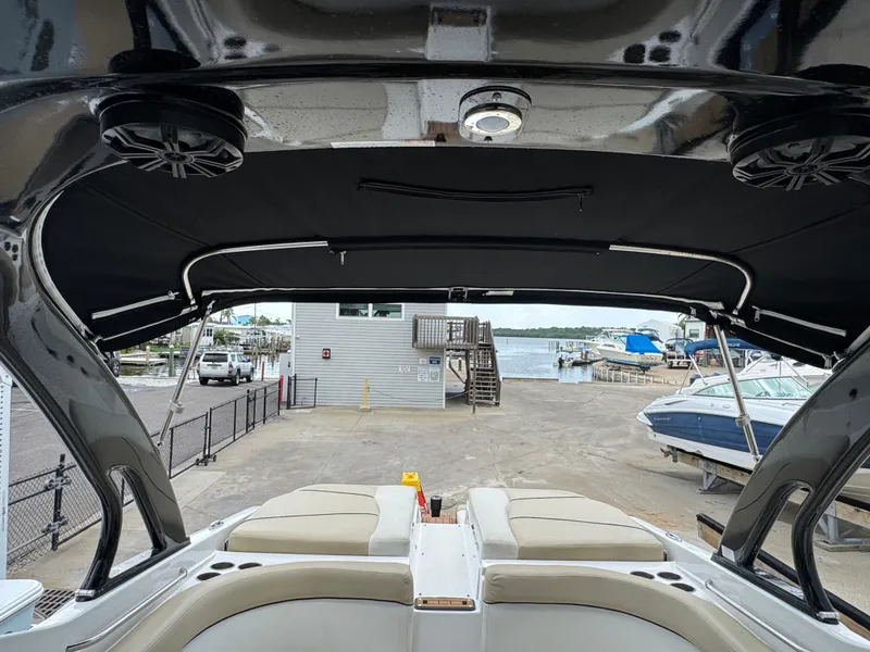 Slide: The Image of 2017 Rinker QX29 BR boat interior with canopy, docked at marina. - 19