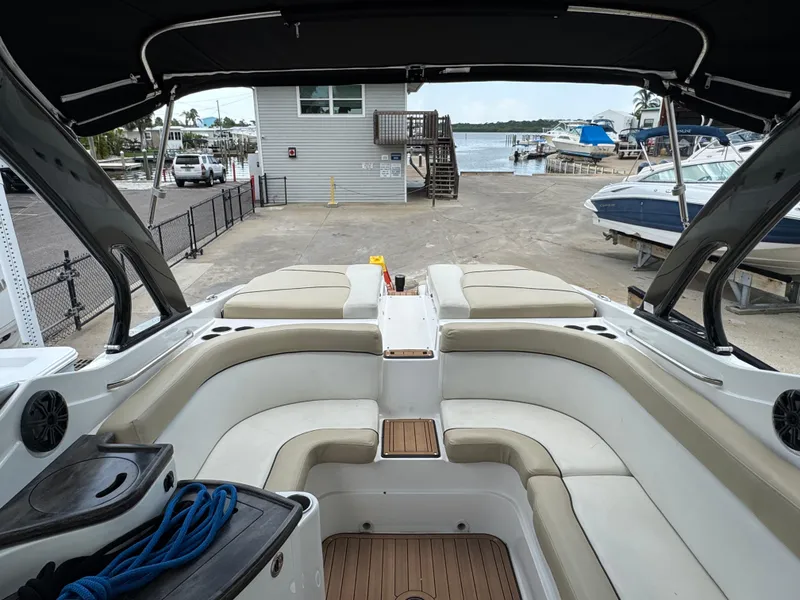 Slide: The Image of 2017 Rinker QX29 BR boat interior with beige seating and dock view. - 20