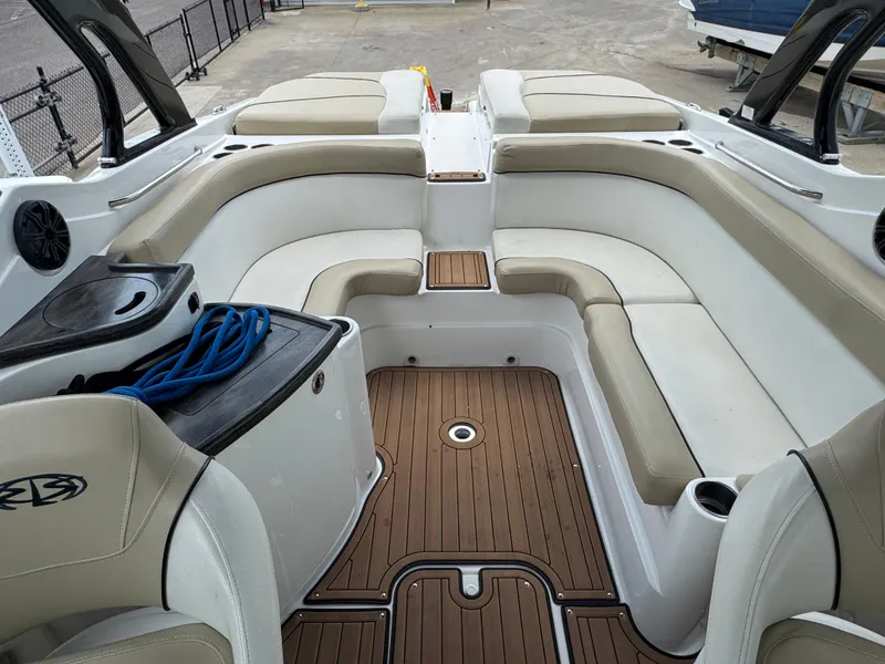 Slide: The Image of 2017 Rinker QX29 BR boat interior with beige seating and wood flooring. - 21