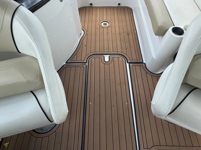 Slide: The Image of 2017 Rinker QX29 BR boat interior with teak flooring and white seating. - 22