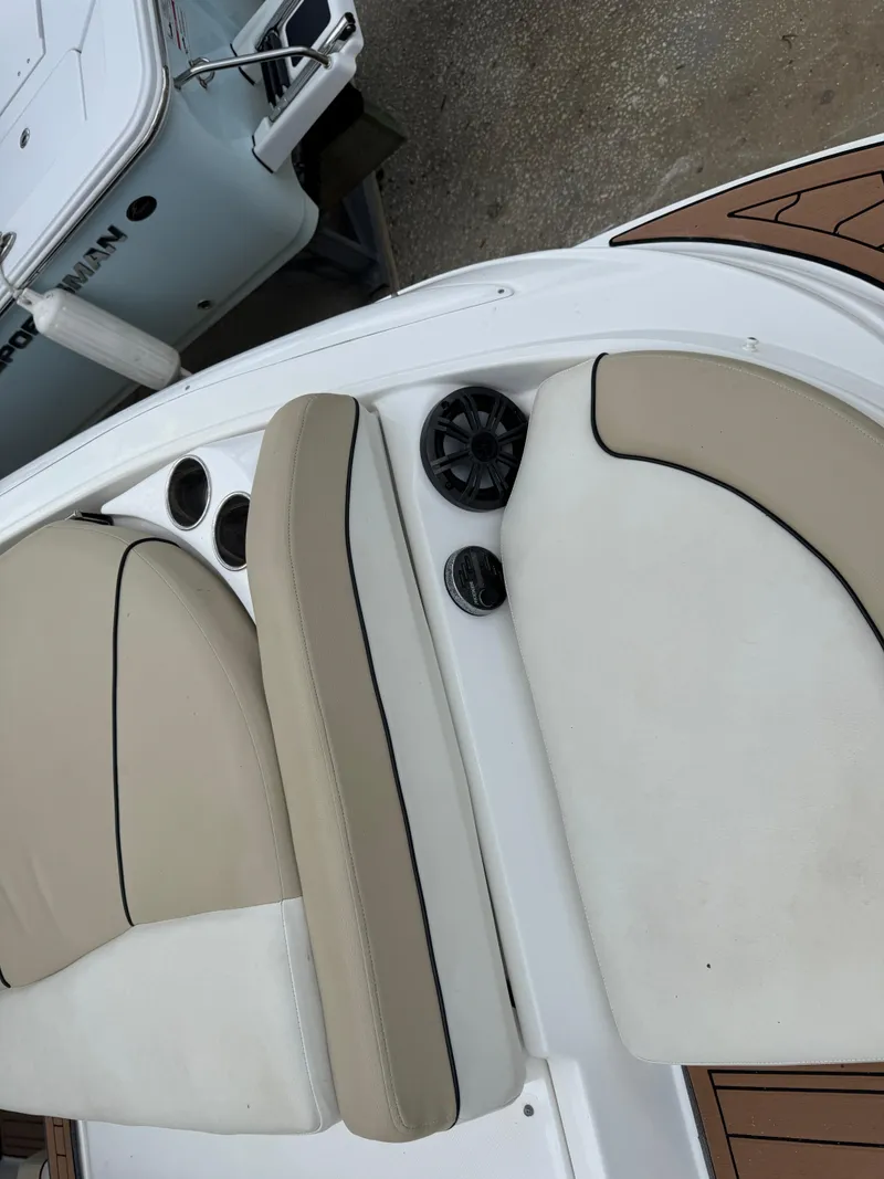 Slide: The Image of 2017 Rinker QX29 BR boat interior with beige seating and cup holders. - 4