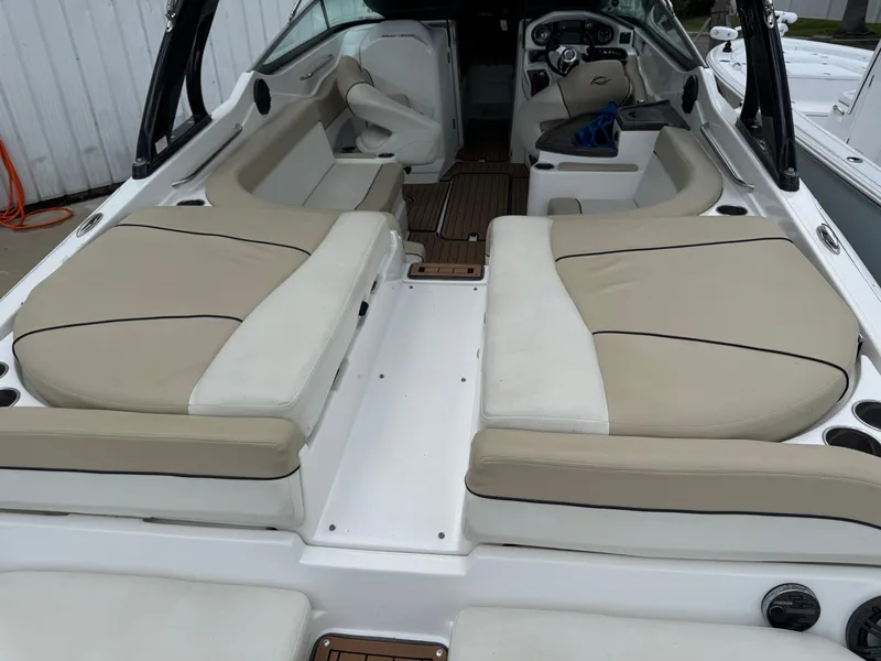 Slide: The Image of 2017 Rinker QX29 BR boat interior with beige seating and modern dashboard. - 5