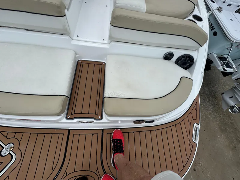 Slide: The Image of 2017 Rinker QX29 BR boat interior with cushioned seating and teak-style flooring. - 7