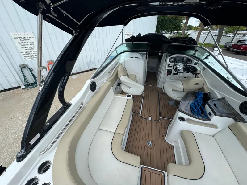 Slide: The Image of 2017 Rinker QX29 BR boat interior with beige seating and wood flooring. - 9