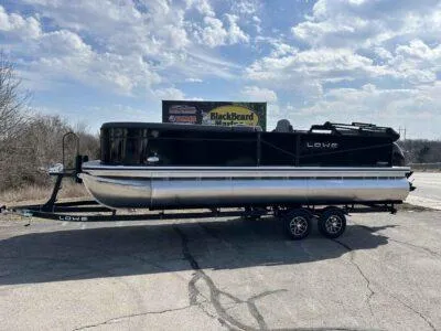 The Image of 2025 Lowe LS 230 pontoon boat on trailer under cloudy sky. - 0