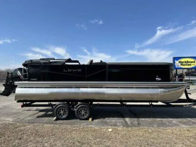 Slide: The Image of 2025 Lowe LS 230 pontoon boat on trailer, parked outdoors under a clear sky. - 2