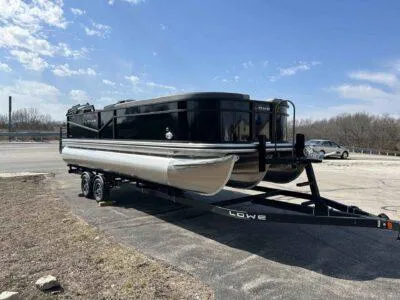 Slide: The Image of 2025 Lowe LS 230 pontoon boat on trailer under clear blue sky. - 4
